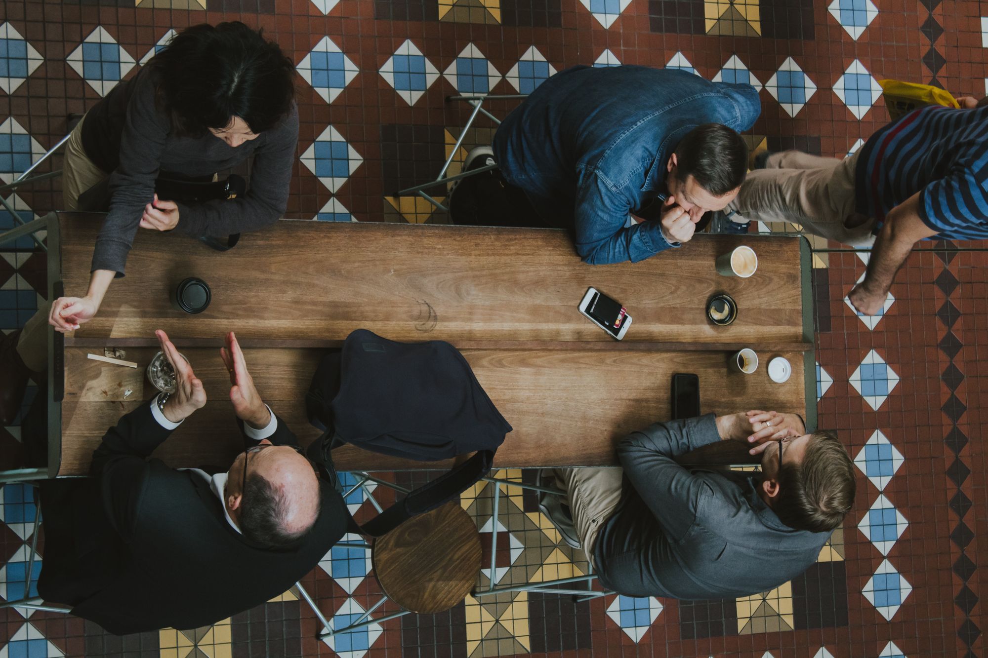 overhead shot of four people talking in coffee shop